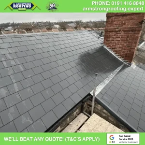 Grey slate roof with brick chimney on a home